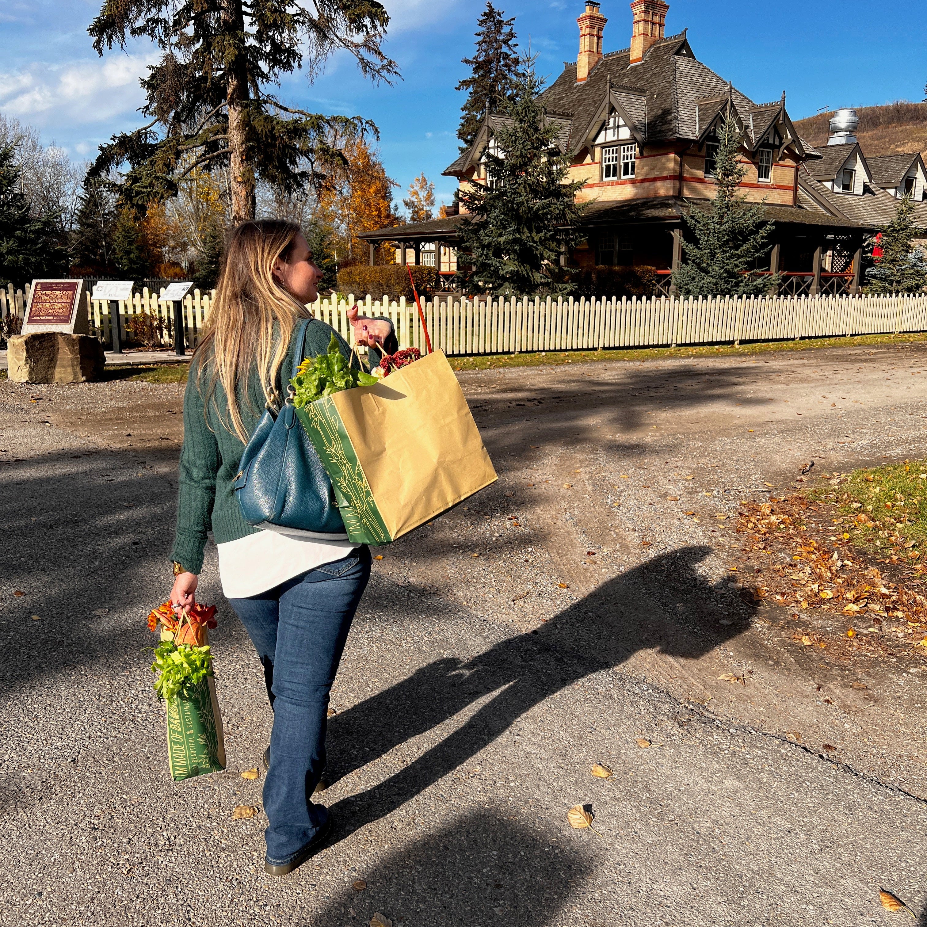 Woman walking outdoors carrying a bamboo paper shopping bag, 